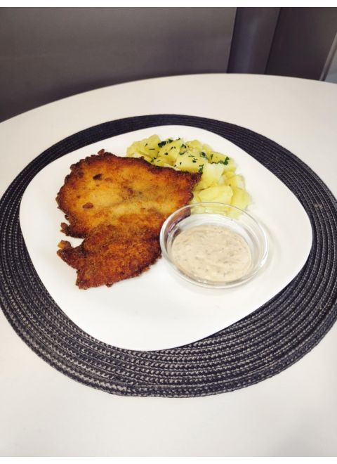 Vyprážaný kurací rezeň obalený v cornflakes 150g, varené zemiaky, dresing